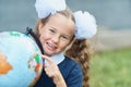 Portrait of a beautiful young first-grader sitting at a desk on the background autumn park. Farewell Bell. day of knowledge. begin