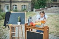 Portrait of a beautiful young first-grader sitting at a desk on the background autumn park. Farewell Bell. day of knowledge. begin