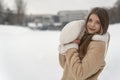 Portrait of a beautiful young girl in a beige coat on a background of winter landscape. Copy space Royalty Free Stock Photo