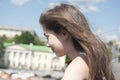 Portrait of beautiful young girl with blowing hair in wind in the city blue sky background Royalty Free Stock Photo