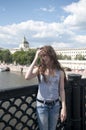 Portrait of beautiful young girl on the bridge blue sky background with blowing hair in wind Royalty Free Stock Photo