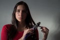 Portrait of a beautiful young girl, with flawless hair, stands at home by the mirror, twists her hair with a curling iron Royalty Free Stock Photo