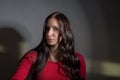 Portrait of a beautiful young girl, with flawless hair, stands at home by the mirror, twists her hair with a curling iron Royalty Free Stock Photo