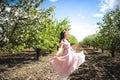 Portrait of a beautiful young girl in a flying bride tender pink dress on a background of green field, she laughs and poses with a Royalty Free Stock Photo