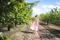 Portrait of a beautiful young girl in a flying bride tender pink dress on a background of green field, she laughs and poses with a Royalty Free Stock Photo