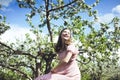 Portrait of a beautiful young girl in a flying bride tender pink dress on a background of green field, she laughs and poses with a Royalty Free Stock Photo