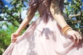 Portrait of a beautiful young girl in a flying bride tender pink dress on a background of green field, she laughs and poses with a Royalty Free Stock Photo