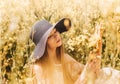 Portrait of a beautiful young girl in a hat against the background of a rapeseed field