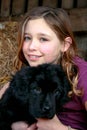 Portrait of a beautiful young girl and her newfoundland puppy hugging