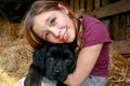 Portrait of a beautiful young girl and her newfoundland puppy hugging