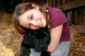 Portrait of a beautiful young girl and her newfoundland puppy hugging