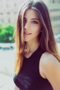 Portrait of a beautiful young girl. Long brown hair. Big eyes and intense gaze. Outdoors, daylight