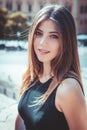 Portrait of a beautiful young girl. Long brown hair. Big eyes and intense gaze. Outdoors, daylight