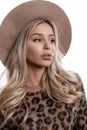 Portrait of a beautiful young girl with natural make-up with lips with long curly blond hair in an elegant hat Royalty Free Stock Photo