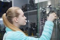 Portrait of beautiful young girl in professional photo equipment store chooses the flexible mini-tripod for camera Royalty Free Stock Photo