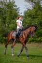 A girl rider trains riding a horse on a spring day