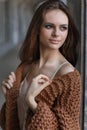 Portrait of a beautiful young girl standing near the wall