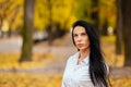 Portrait of a beautiful young girl walking along the autumn park