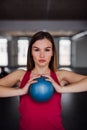 A portrait of young girl or woman doing exercise with a ball in a gym. Royalty Free Stock Photo