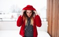 A portrait of young girl or woman with earphones outdoors, listening to music.