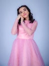 Portrait Of Beautiful Young girle Standing Against blue Background,girl in a pink dress,Happy cheery smiling young cute girl