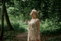 Portrait of a beautiful graceful blonde woman dancing. In the woods in summer.