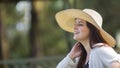 Portrait of beautiful young Hispanic woman with long hair with a hat very cheerful sitting on a park bench against a background of