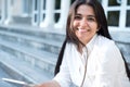 Portrait of a beautiful young indian girl. Business woman, smiling, sitting on the steps, holding a tablet in her hands. close-up Royalty Free Stock Photo