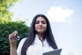 Portrait of an indian girl. Business lady holding glasses and tablet in her hands. Outdoors Royalty Free Stock Photo