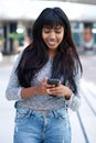 Beautiful young Indian woman walking with mobile phone outdoors in the city Royalty Free Stock Photo