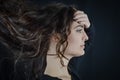 Portrait of a beautiful young Italian woman with very long brown hair in profile looking seriously in front of her