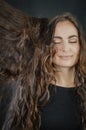 Portrait of a beautiful young Italian woman with very long brown hair who is smiling with her eyes closed Royalty Free Stock Photo