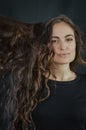 Portrait of a beautiful young Italian woman with very long brown hair who is smiling and looking at the camera Royalty Free Stock Photo