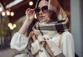Portrait of beautiful young lady in sunglasses with scarf covering head. Stylish woman. Royalty Free Stock Photo
