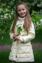 Portrait of a beautiful young long-haired girl. Adorable child having fun in blossom cherry garden on beautiful spring day Royalty Free Stock Photo