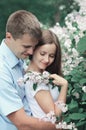 Portrait beautiful young loving couple hugging in blooming garden Royalty Free Stock Photo