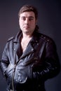 Portrait of beautiful young man in a leather jacket on a gray ba Royalty Free Stock Photo