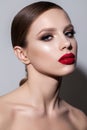 Portrait of a beautiful young model with bright evening make up, perfect skin, red lips and smooth hairdo Royalty Free Stock Photo