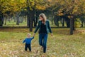 Portrait of a beautiful young mother with her son walks in the autumn park Royalty Free Stock Photo