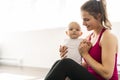 A Portrait of beautiful young mother in sports wear with her charming little baby in training session Royalty Free Stock Photo