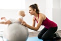 A Portrait of beautiful young mother in sports wear with her charming little baby in training session Royalty Free Stock Photo