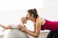 A Portrait of beautiful young mother in sports wear with her charming little baby in training session Royalty Free Stock Photo