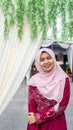 A portrait of beautiful young Muslim Malay woman wearing a hijab and dress called `Baju Kurung`