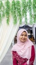 A portrait of beautiful young Muslim Malay woman wearing a hijab and dress called `Baju Kurung`