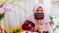 A portrait of beautiful young Muslim Malay woman wearing a hijab dress called `Baju Kurung`