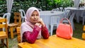 A portrait of beautiful young Muslim Malay woman wearing a hijab and modern traditional dress called