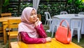 A portrait of beautiful young Muslim Malay woman wearing a hijab and modern traditional dress called