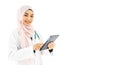 Portrait of beautiful young Muslim woman doctor using digital tablet computer, standing isolated on white background Royalty Free Stock Photo