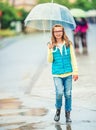 Portrait of beautiful young pre-teen girl with umbrella under rain