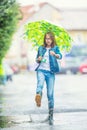 Portrait of beautiful young pre-teen girl with umbrella under rain